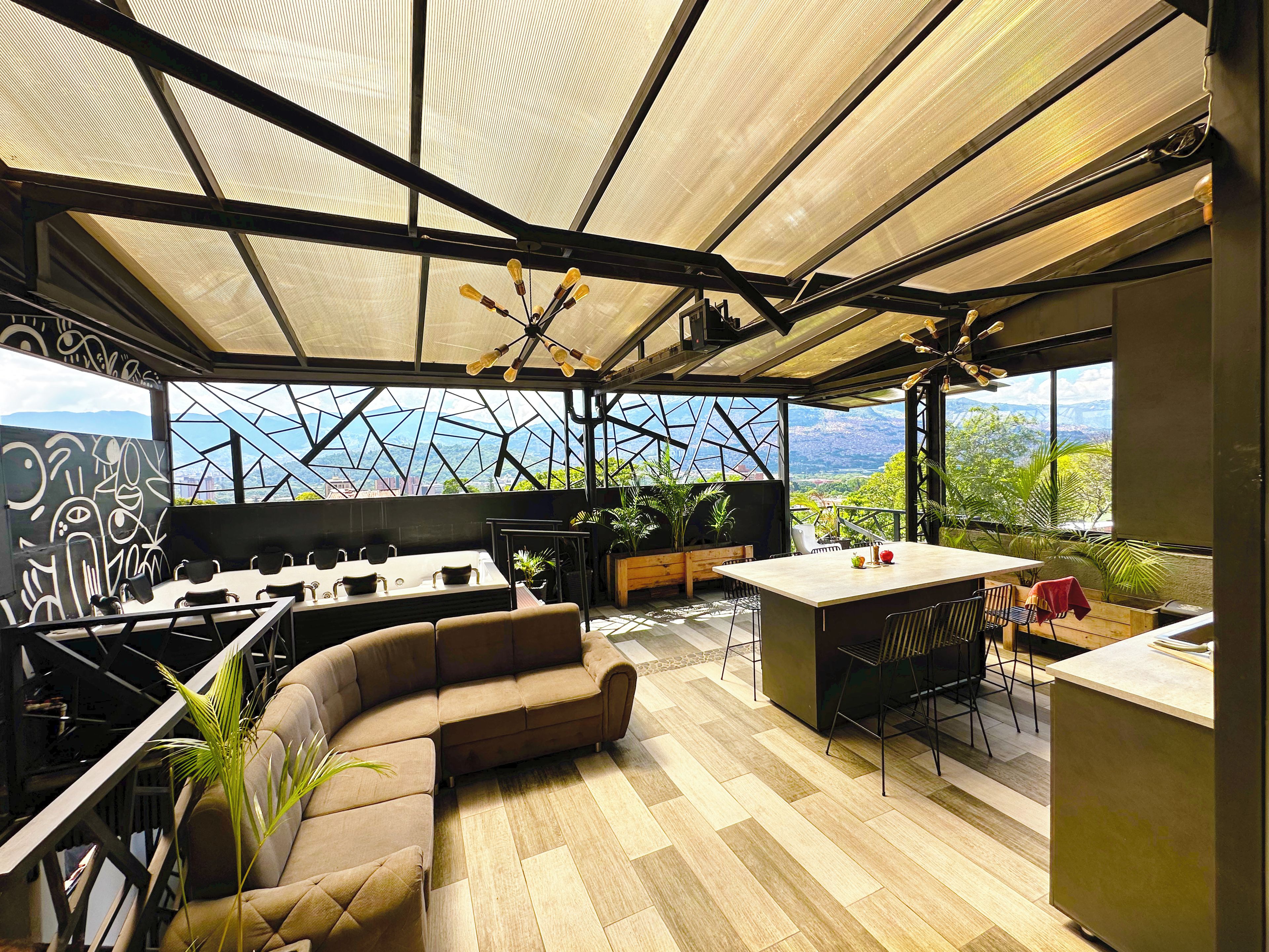 A modern kitchen with a large island, seating area, and a view of mountains.