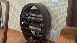 Una botellera con varias botellas frente a una pared de azulejos.