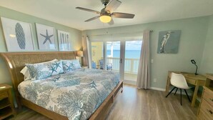A bedroom with a bed, a desk, a chair, and a view of the ocean. - Pelican's Perch: Kayaks, Views & More! (Escambia County)