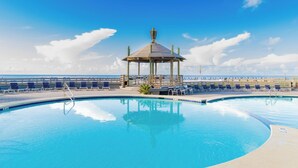 A swimming pool with lounge chairs and a gazebo. - Sunrise Serenity Summer House 1101A (Orange Beach)