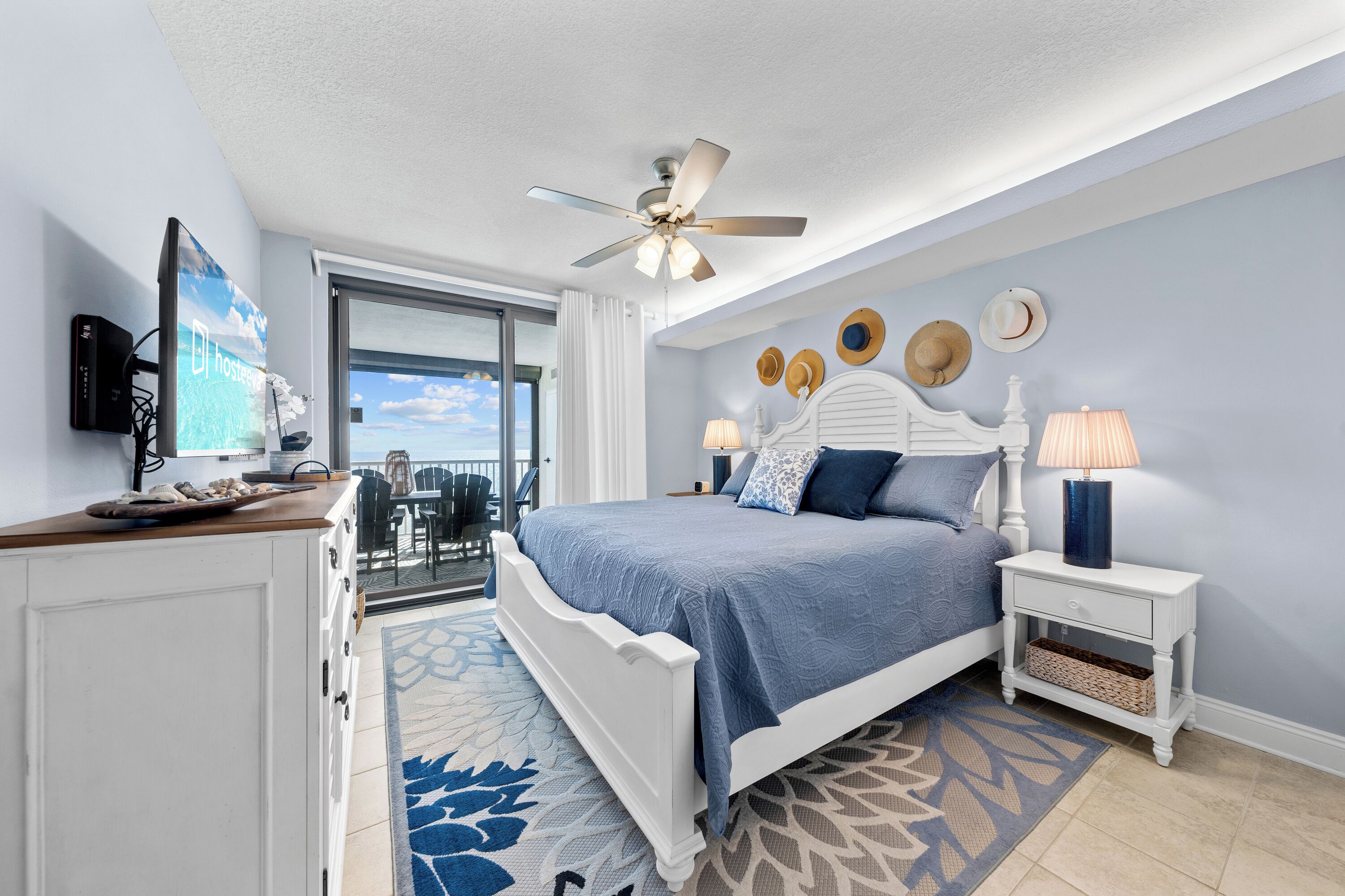 A bedroom with a bed, nightstand, and a ceiling fan.