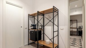 Μια μικρή, λειτουργική κουζίνα με μηχανή καφέ, βραστήρα και ένα μικρό ψυγείο.