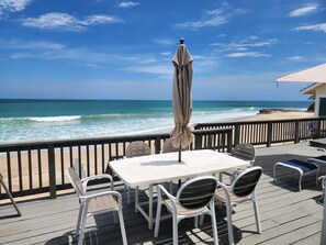 A deck with a table and chairs overlooking the ocean. - Stuart Beach House- Ocean-to-river with stunning views, private dock & hot tub! (Stuart)