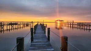 A wooden pier leading to a gazebo at sunset. - Stuart Beach House- Ocean-to-river with stunning views, private dock & hot tub! (Stuart)