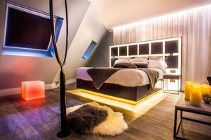 A modern bedroom with a bed, bedside table, and a wall-mounted TV. - Legend Hôtel Paris (Paris)