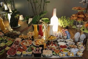 A buffet with various food items and beverages, including fruits, cheeses, and pastries. - Legend Hôtel Paris (Paris)