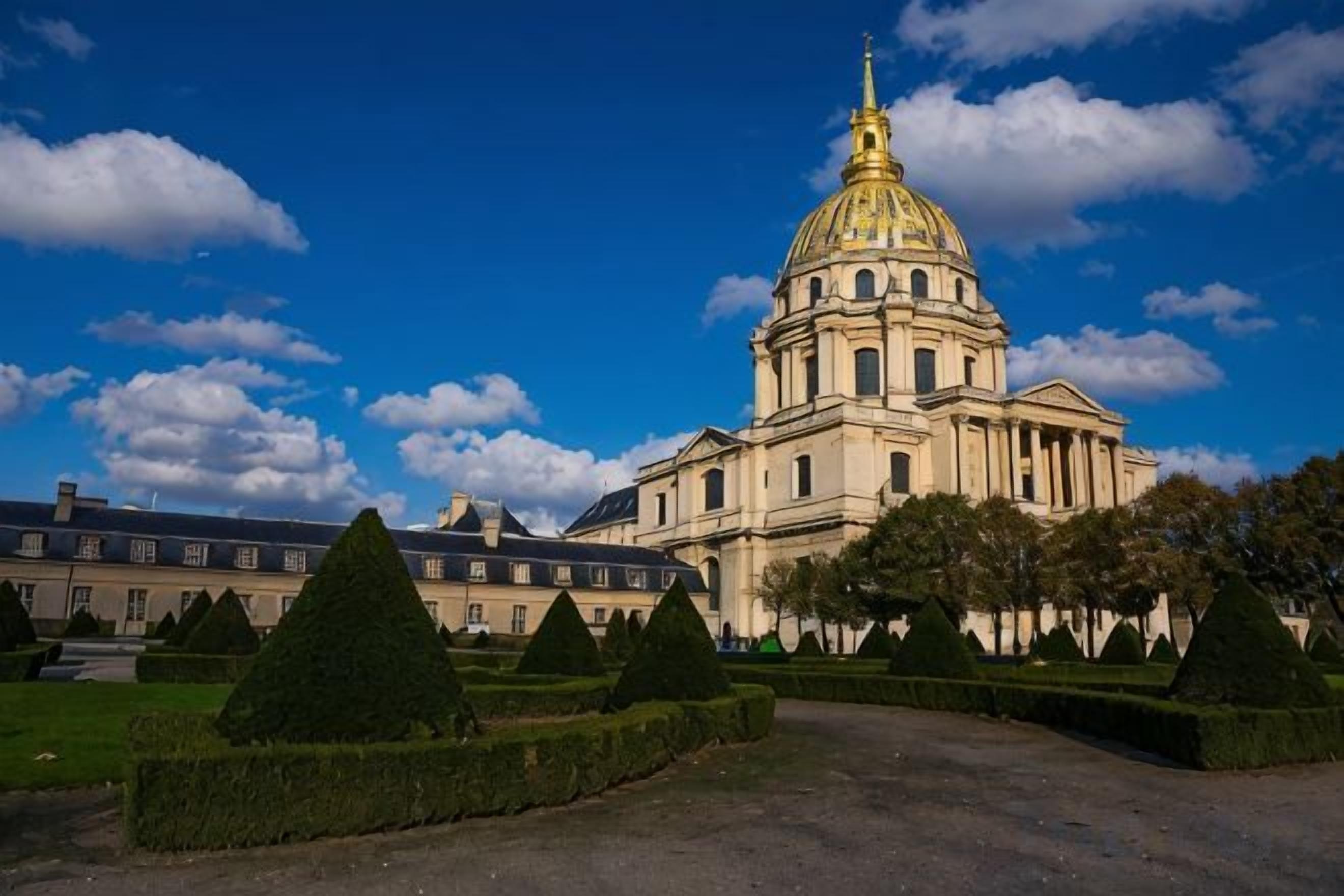 A large building with a prominent dome and symmetrical landscaping.