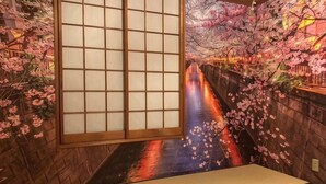 Ein traditioneller japanischer Raum mit Tatami-Boden, Shoji-Schirm und Kirschblütendekoration.