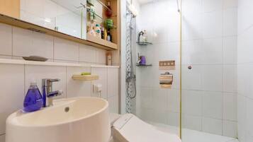 Une salle de bain moderne avec un grand lavabo, des toilettes et une douche.