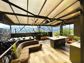 A modern kitchen with a large island, seating area, and a view of mountains. - Luxury Suite - Rooftop, Jacuzzi & Balcony (Medellín)