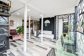 Un interior moderno con una zona de comedor, un sofá y una cocina al fondo.