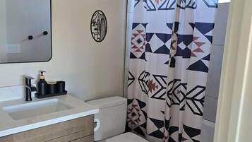 Chuveiro, secador de cabelo, toalhas de banho, sabonete