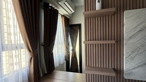Un couloir doté d’un plancher en bois, d’un climatiseur fixé au mur et d’un mur décoratif en marbre.