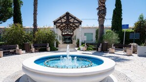 A fountain with water jets in the center, surrounded by stone tiles and benches. - Le Mimose Family Camping Village Apartment Superior for 6 people (Porto Sant'Elpidio)