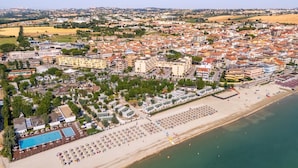An aerial view of a coastal town with a beach, a swimming pool, and a variety of buildings. - Le Mimose Family Camping Village Apartment Superior for 6 people (Porto Sant'Elpidio)