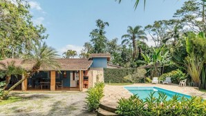 A house with a swimming pool, surrounded by lush greenery and palm trees. - House With Pool and Barbecue in Itamambuca Cpi0130 (Ubatuba)