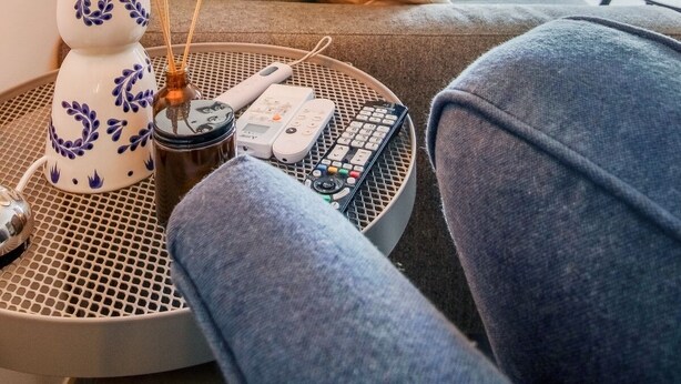 Un soggiorno moderno con divano, tavolino, lampada e vista sull'esterno.