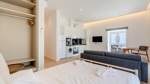 A modern hotel room with a bed, a sofa, a kitchenette, and a dining area. - Old Town Studio F 150m Praia T nel (Albufeira)