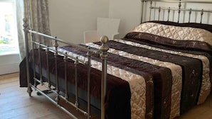 Ένα κρεβάτι με μεταλλικό σκελετό και ένα καπιτονέ κάλυμμα.