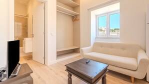 A living room with a beige sofa, a wooden coffee table, and a TV stand. - Old Town Studio G 150m Praia T nel (Albufeira)