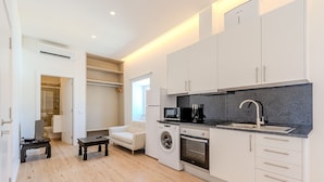 A modern kitchen with white cabinets, a built-in washing machine, and a microwave. - Old Town Studio G 150m Praia T nel (Albufeira)