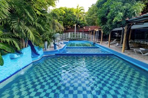Una piscina al aire libre, sillones reclinables de piscina