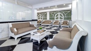 A modern living room with a checkered floor, white sofas, and a coffee table. - Hotel Playa Salguero By GEH Suites  (Santa Marta)