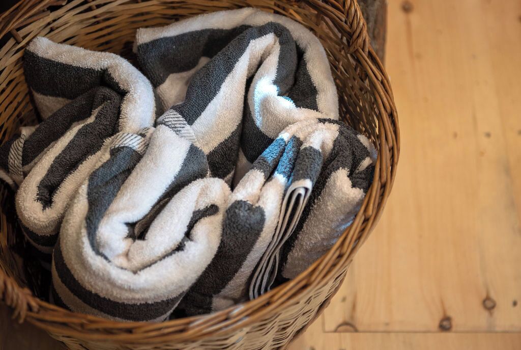 Un cesto di vimini con coperte arrotolate e motivi a righe.