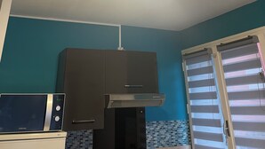 A kitchen with a microwave, a stove, and a ceiling fan.