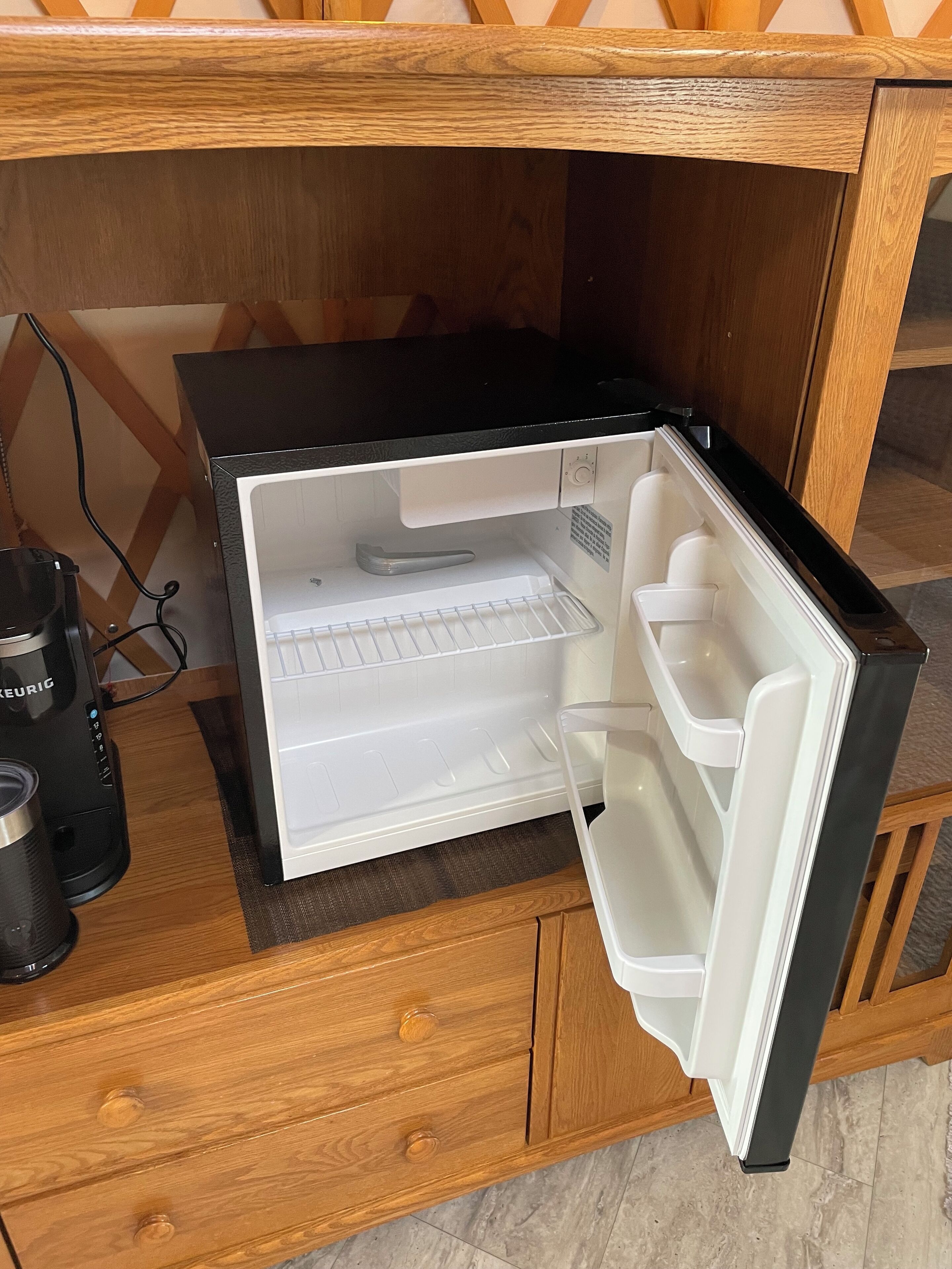 A kitchen with a built-in refrigerator, a coffee maker, and wooden cabinetry.