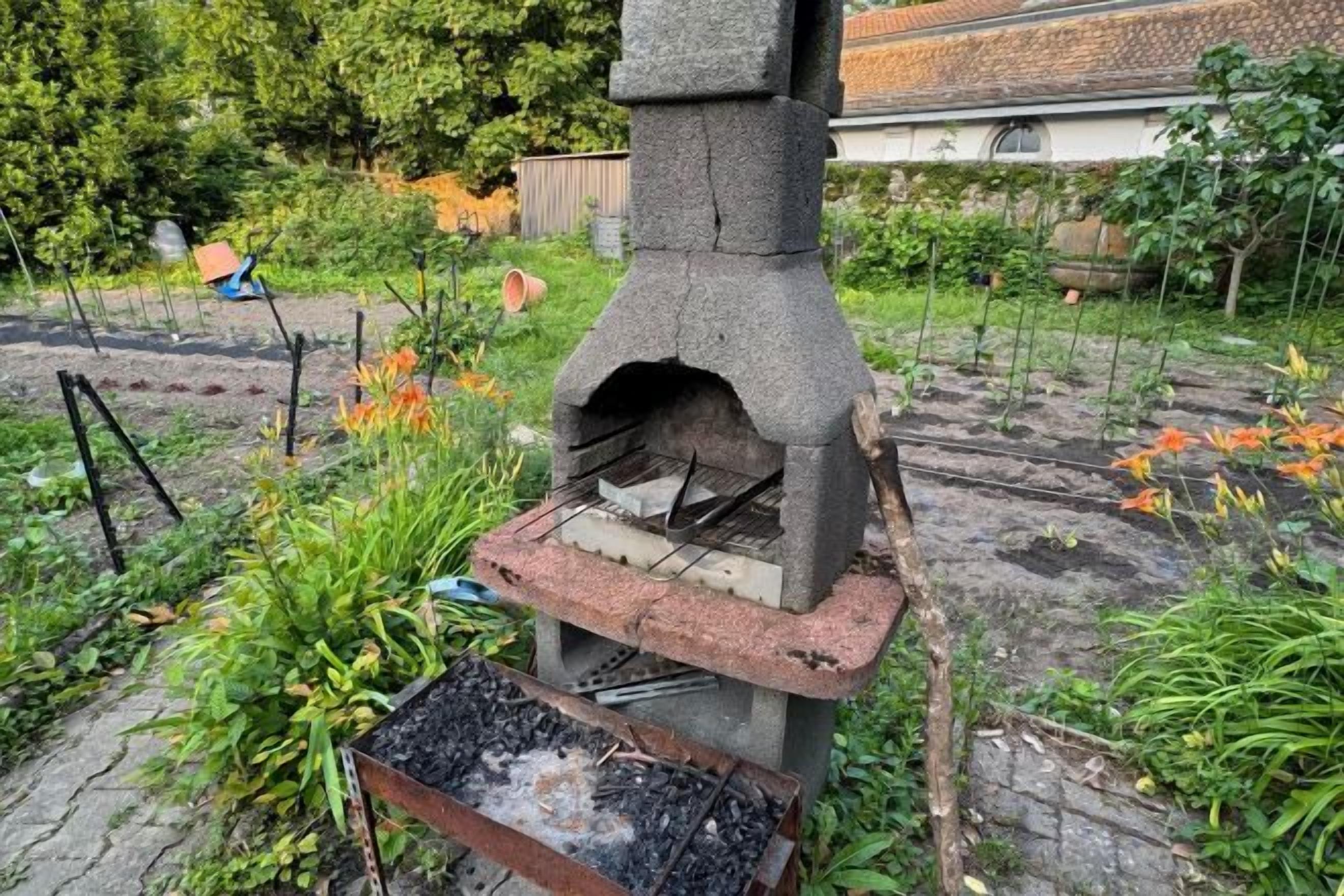 An outdoor stone oven in a garden setting.