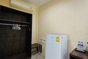 A room with a white refrigerator, a water dispenser, and a coat rack. - Samran Resort (Phuket)