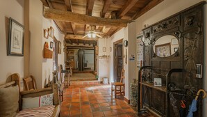 A hallway with wooden beams, a tiled floor, and a door with a mirror and umbrella. - Rural House 'El Escondite De Los Duendes' with Mountain View, Private Garden and Wi-Fi (Tanarro)