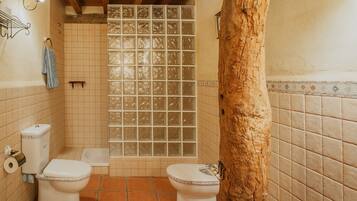 Un baño con dos inodoros, ducha y bañera.