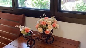 A wooden bench with a small cart holding a bouquet of flowers. - Rommaiplaitawan hotel & resort (Nakhon Ratchasima)