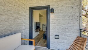 Ein modernes Interieur mit Steinwand, einer Holzbank und einer Treppe, die in einen anderen Raum führt.