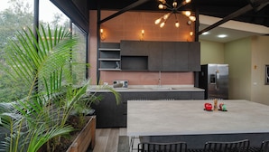A modern kitchen with a large island, built-in appliances, and a dining area with chairs. - Prado centro #10 Luxury Suite - Rooftop, Jacuzzi & Balcony (Medellín)