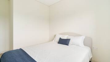 Une chambre à coucher avec un lit, une tête de lit et une prise électrique au mur.