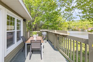 A covered deck with a table and chairs, overlooking a body of water and surrounded by trees. - Kamouraska, Lac et nature (Mont-Carmel)