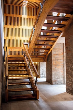 A wooden staircase with a metal railing, leading to a high ceiling with wooden slats. - Casa Santa Clara-Colonial Boutique Hotel (Quito)