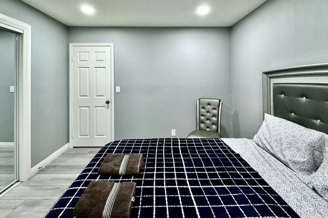Una camera da letto con un letto, una sedia e una porta.