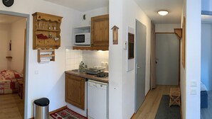 A compact kitchen with wooden cabinets, a microwave, a sink, and a dishwasher. - 3-bedroom apartment for 6 in Saint-François-Longchamp (Saint-François-Longchamp)