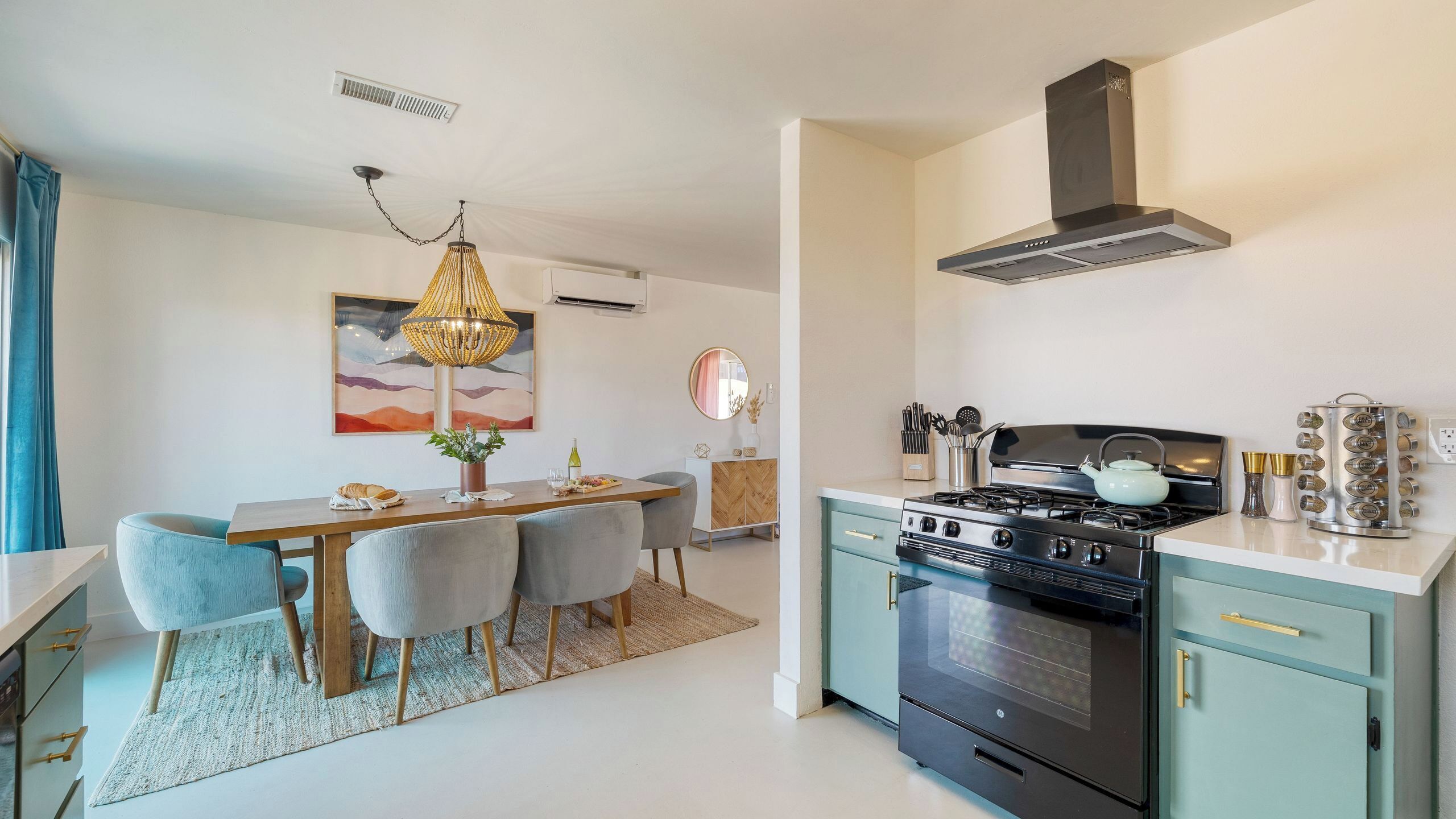 Une cuisine moderne équipée d’une cuisinière, d’un four et d’un coin repas avec des chaises et une table.