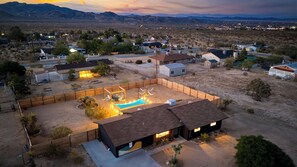 A residential area with houses, a swimming pool, and mountains in the background.