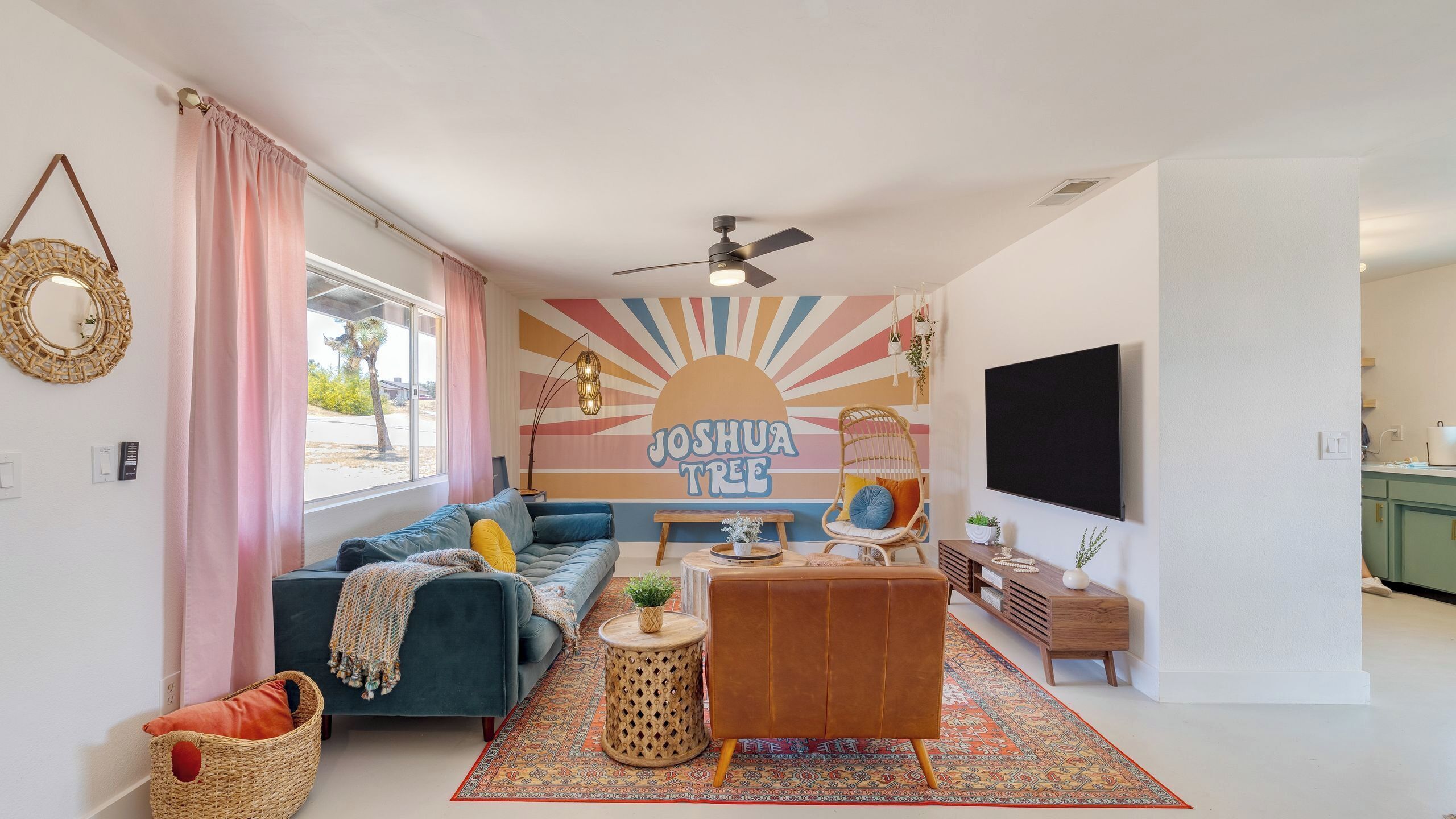 A modern living room with a sofa, a coffee table, a TV, and a wall mural.