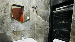 Un bagno moderno con una schiena di marmo, un lavandino bianco e un water.