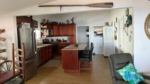 Eine geräumige Küche mit Holzausstattung, Edelstahlgeräten und einer zentralen Kochinsel.