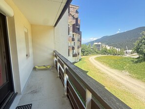A balcony with a view of a road and buildings in the distance.