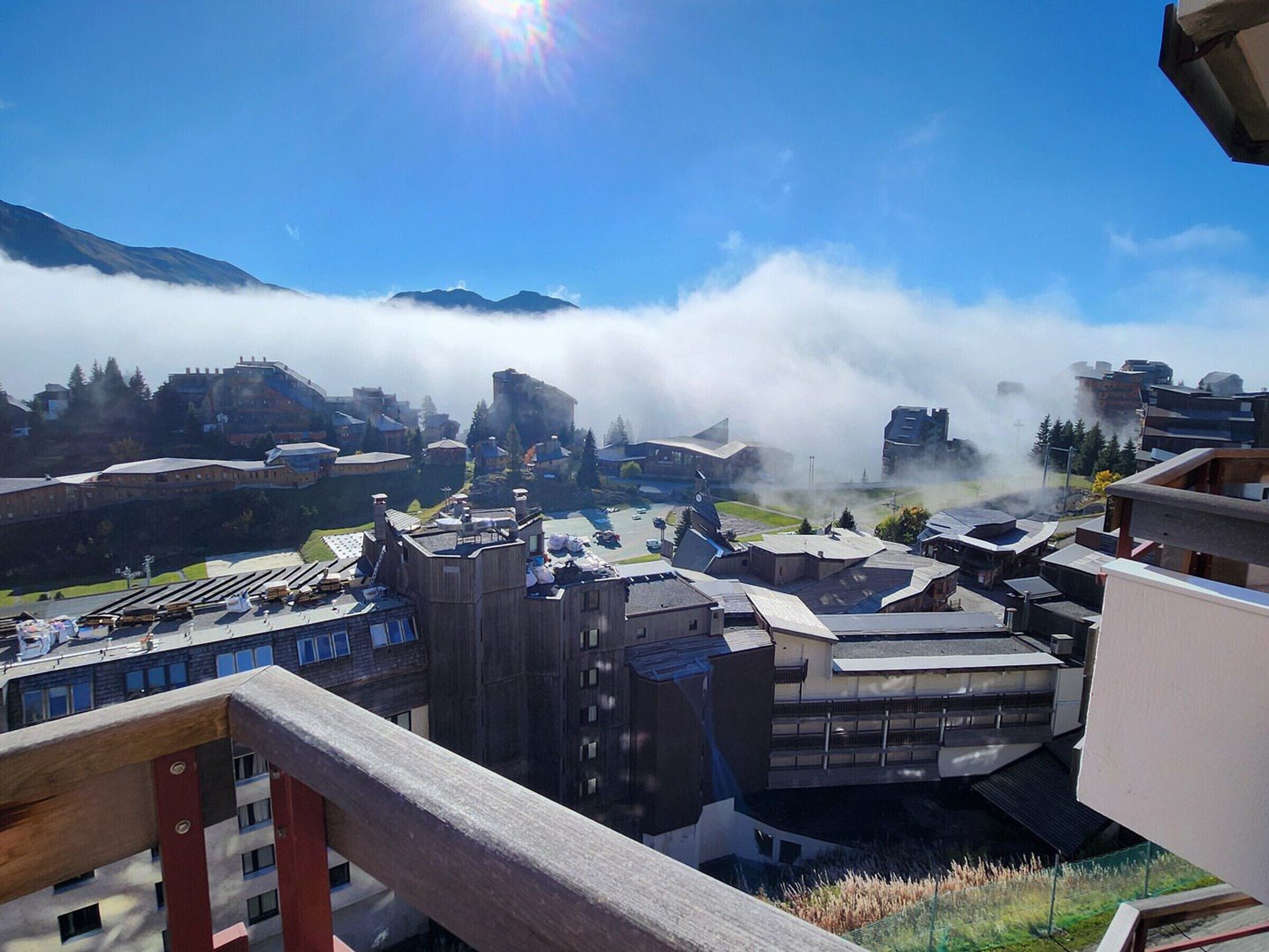 A cityscape with modern buildings, a prominent mountain in the background, and a clear sky.