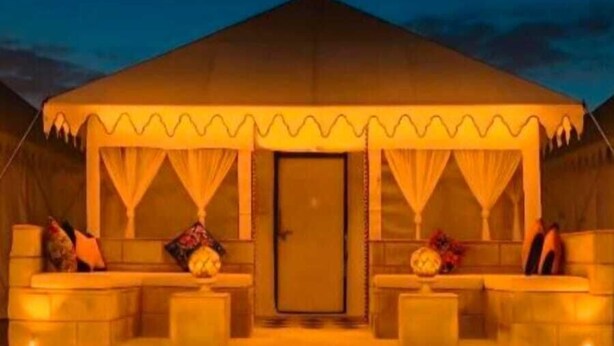 A desert island camp and resort with a tent-like structure, a door, and a few cushions on the steps. - Desert Island Camp & Resort Jaisalmer (Jaisalmer)